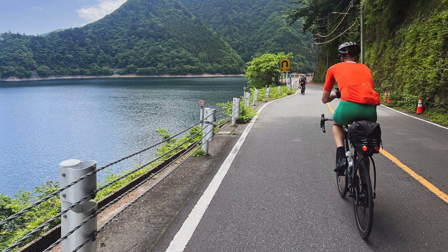 Lysandre cycling along Lake Okutama, Japan